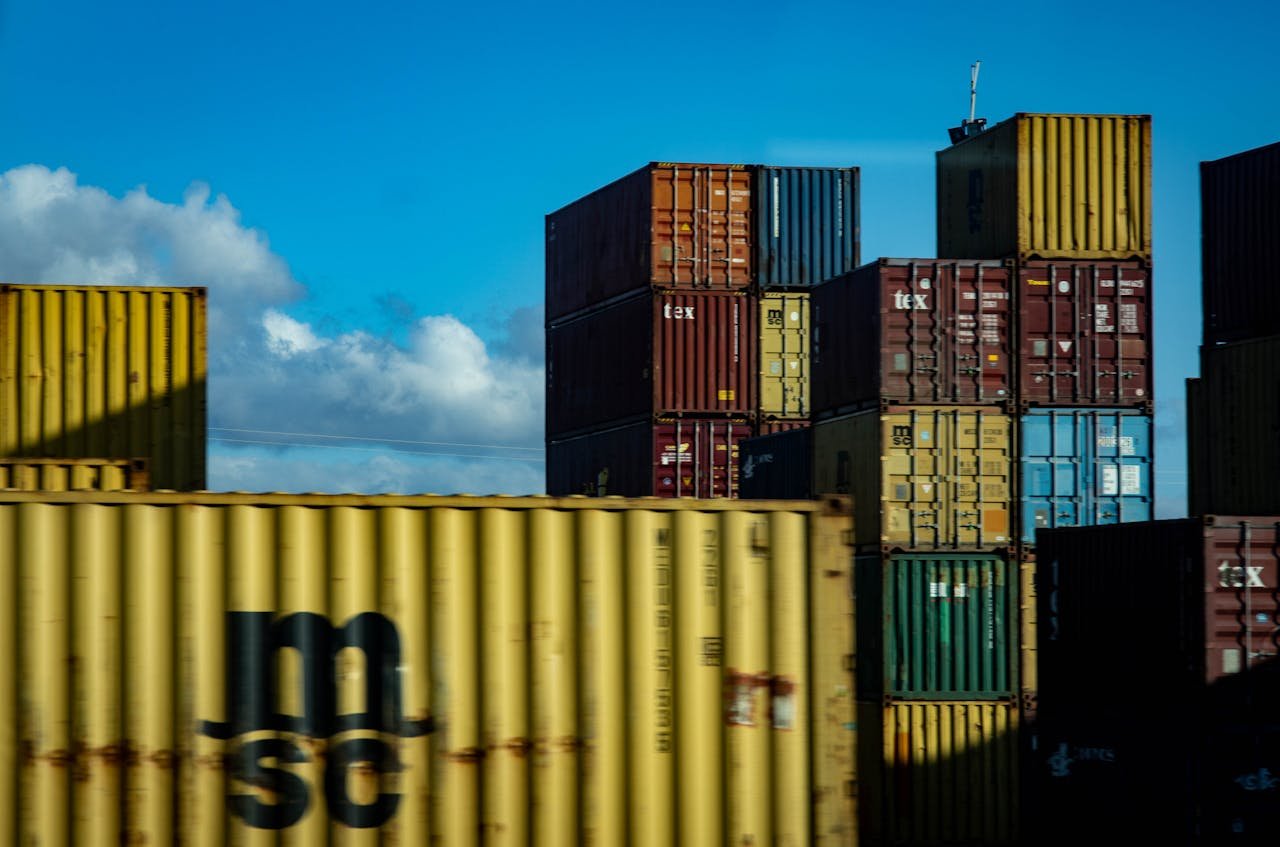 why-choose-us A vibrant display of stacked cargo containers against a clear blue sky.