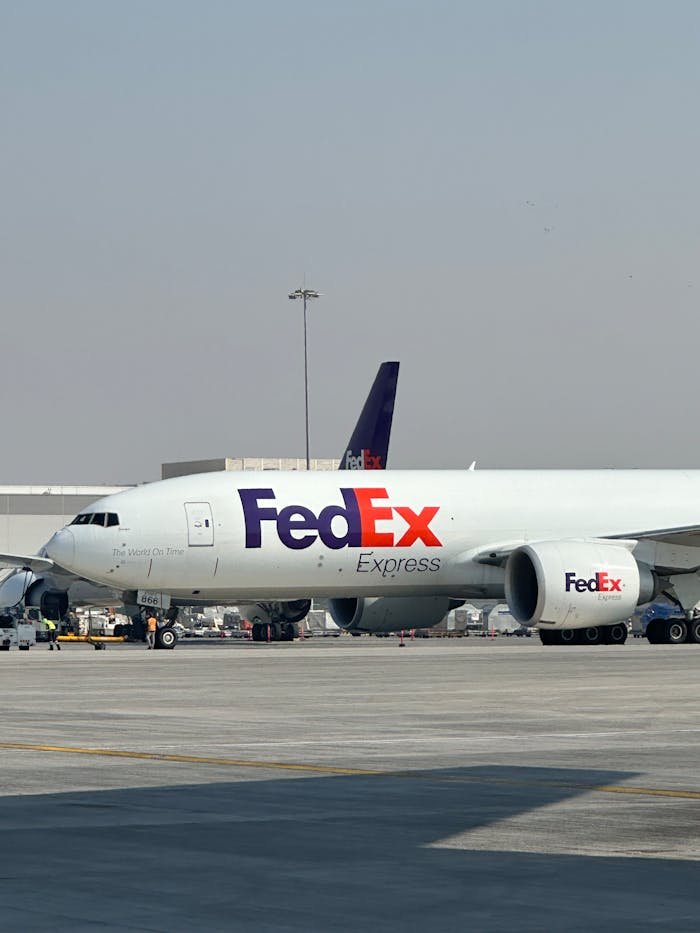 FedEx cargo aircraft parked at Dubai International Airport on a clear day.